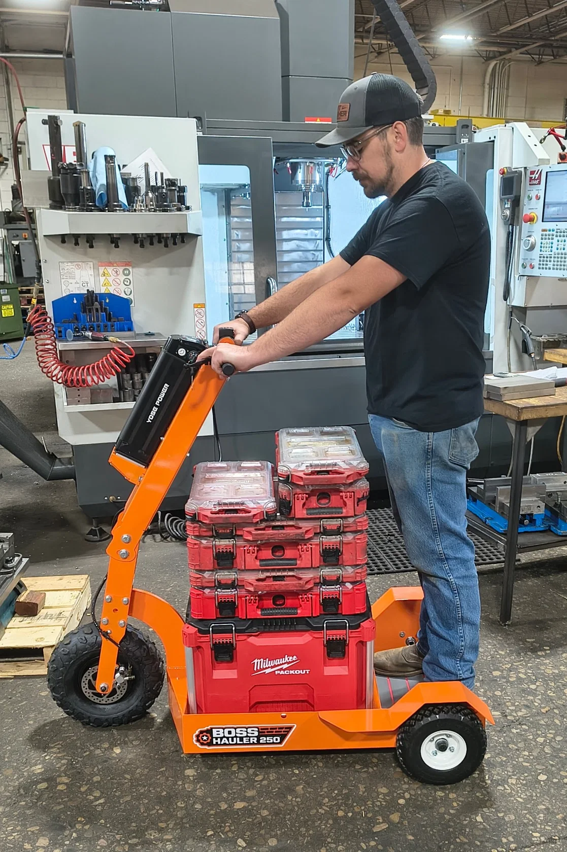 Boss Hauler 250 in use by a worker in the manufacturing shop carrying tool cases